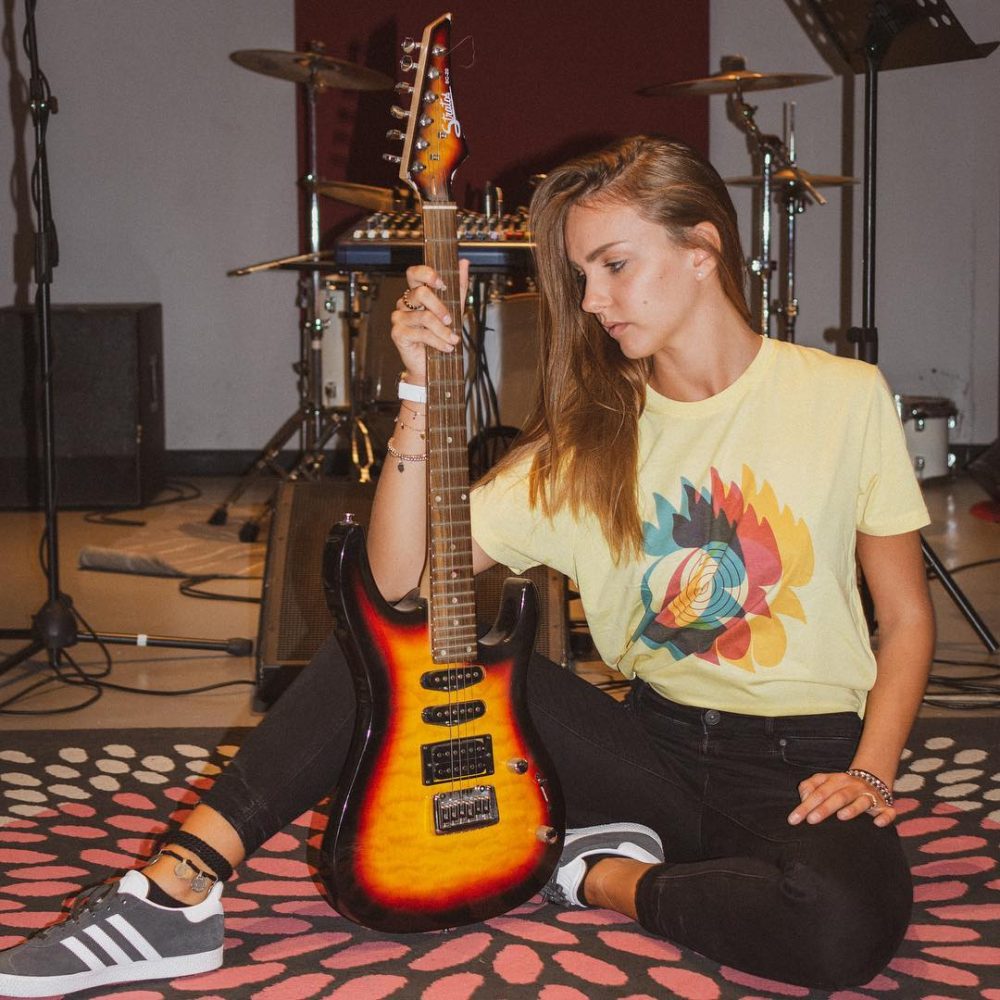 ragazza che suona la chitarra con la maglietta amadori original